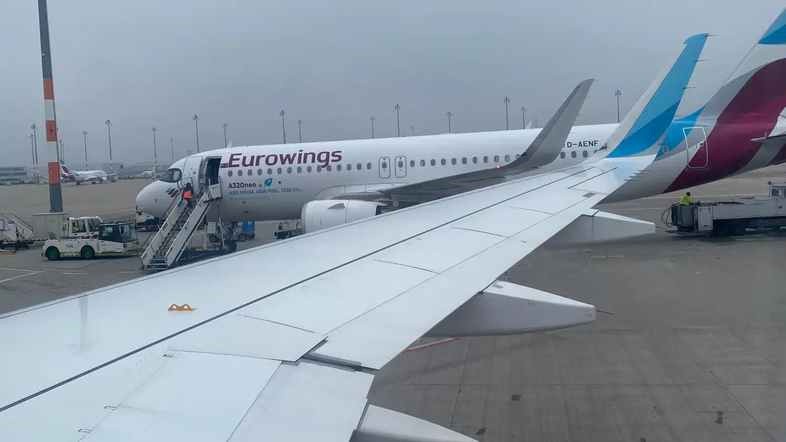 Eurowings Airbus A320neo am Gate, im Vordergrund die Tragfläche eines weiteren Eurowings Flugzeugs