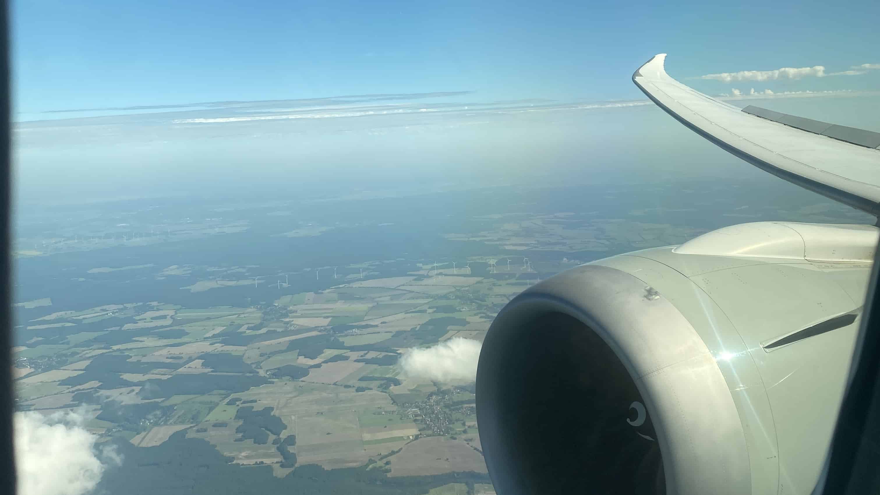 Blick aus dem Flugzeugfenster auf Tragfläche und Triebwerk im Reiseflug