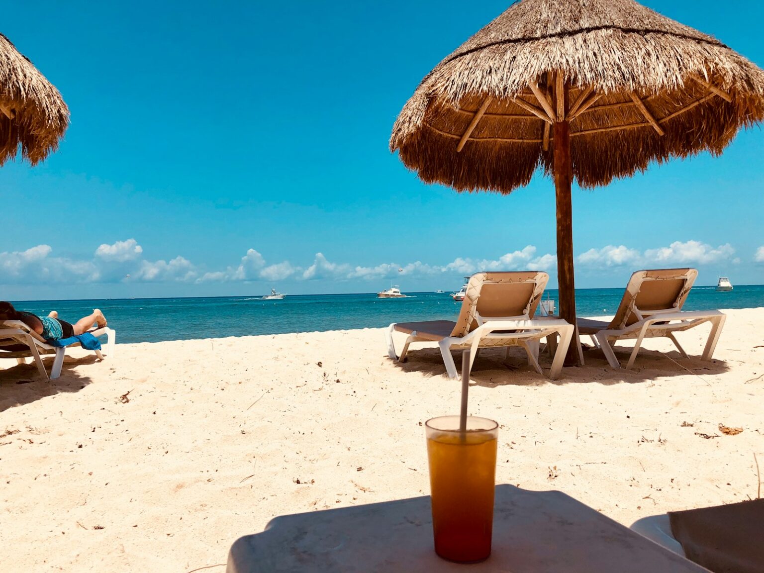 Brauner Sonnenschirm und zwei Strandstühle auf dem Sandstrand