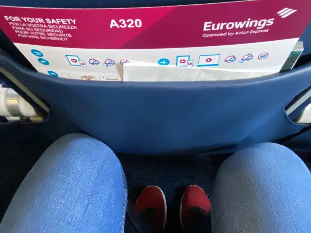 Beinfreiheit in der Economy Class eines Eurowings A320 mit Sicherheitskarte in der Sitztasche