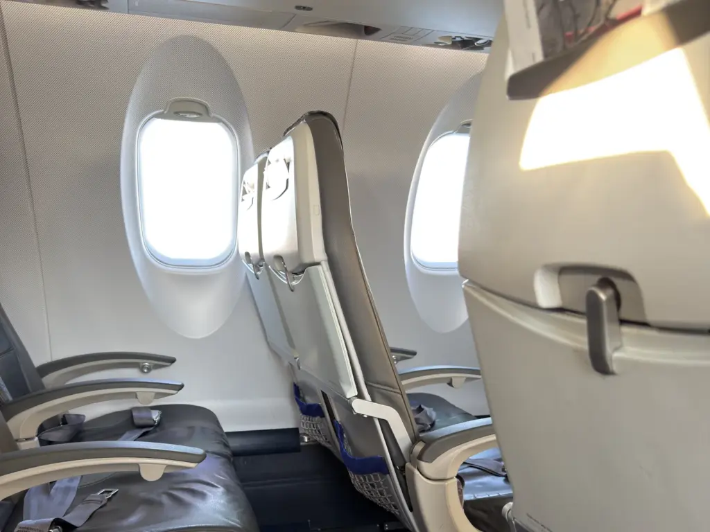 Economy Kabine eines Regionaljets mit Sitzreihen und ovalen Fenstern