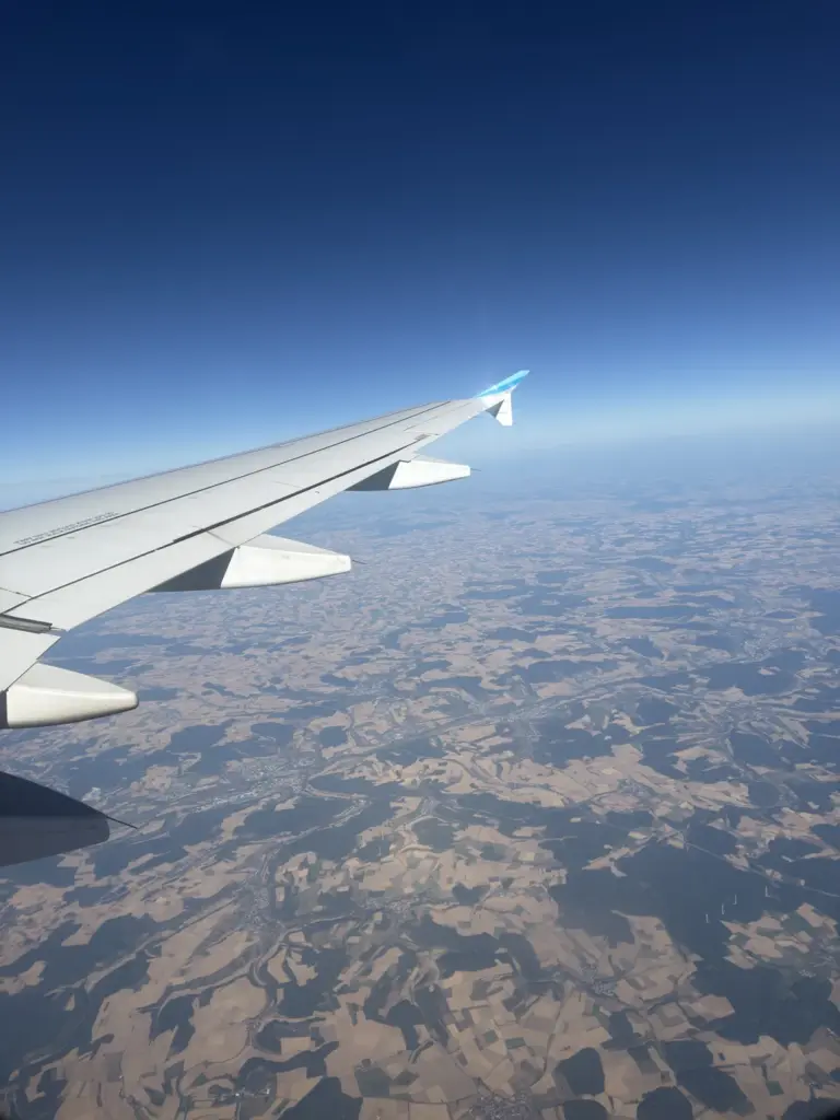 Flugzeugflügel mit Winglet im Reiseflug über Feldern