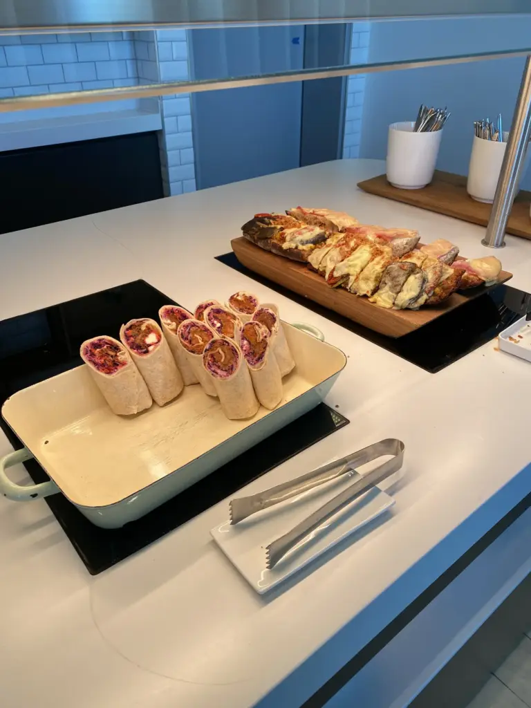 Buffet in der Lufthansa Business Lounge am BER mit Wraps und überbackenem Baguette