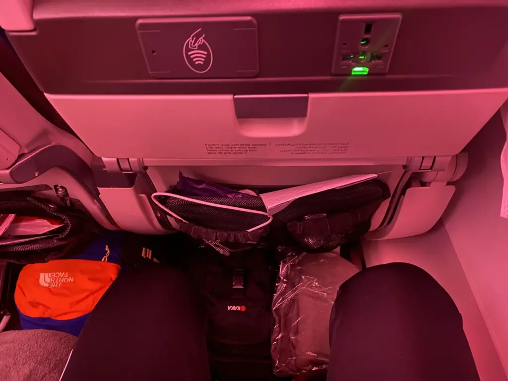 Beinfreiheit in der Qatar Airways Economy mit Rucksack unter dem Vordersitz, Steckdose und USB Anschluss