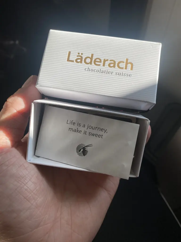 Kleine Schachtel Läderach Schokolade von Qatar Airways mit dem Spruch Life is a journey, make it sweet