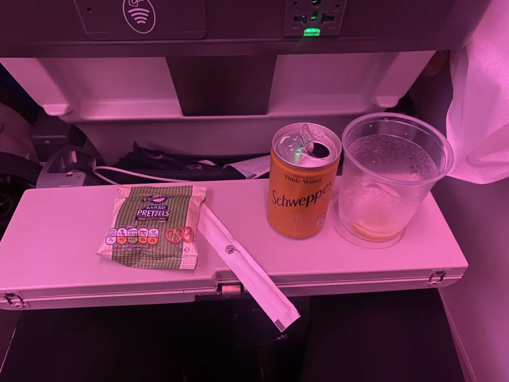 Snack in der Qatar Airways Economy mit Brezeln und Tonic Water auf dem halben Klapptisch