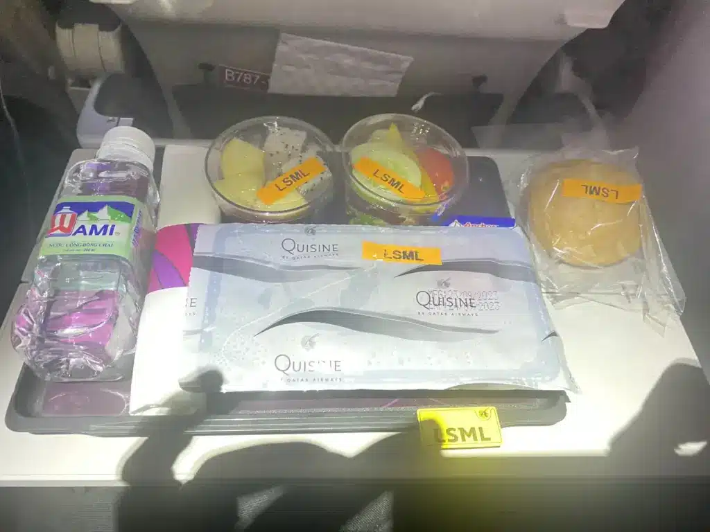 Salzarmes Sondermenü LSML bei Qatar Airways mit gelben Aufklebern auf Schalen und Besteck