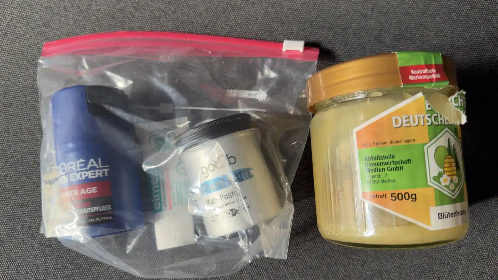 Durchsichtiger 1-Liter-Beutel mit kleinen Pflegeprodukten neben einem 500-g-Honigglas